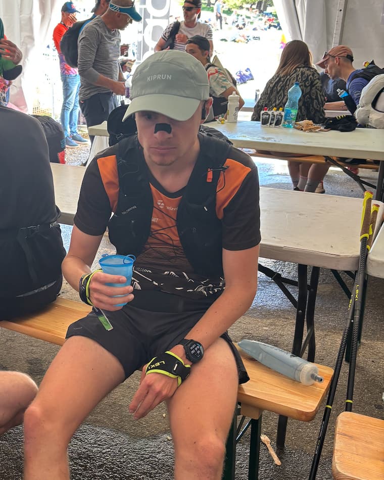 Coureur épuisé assis sous la tente d'un ravitaillement